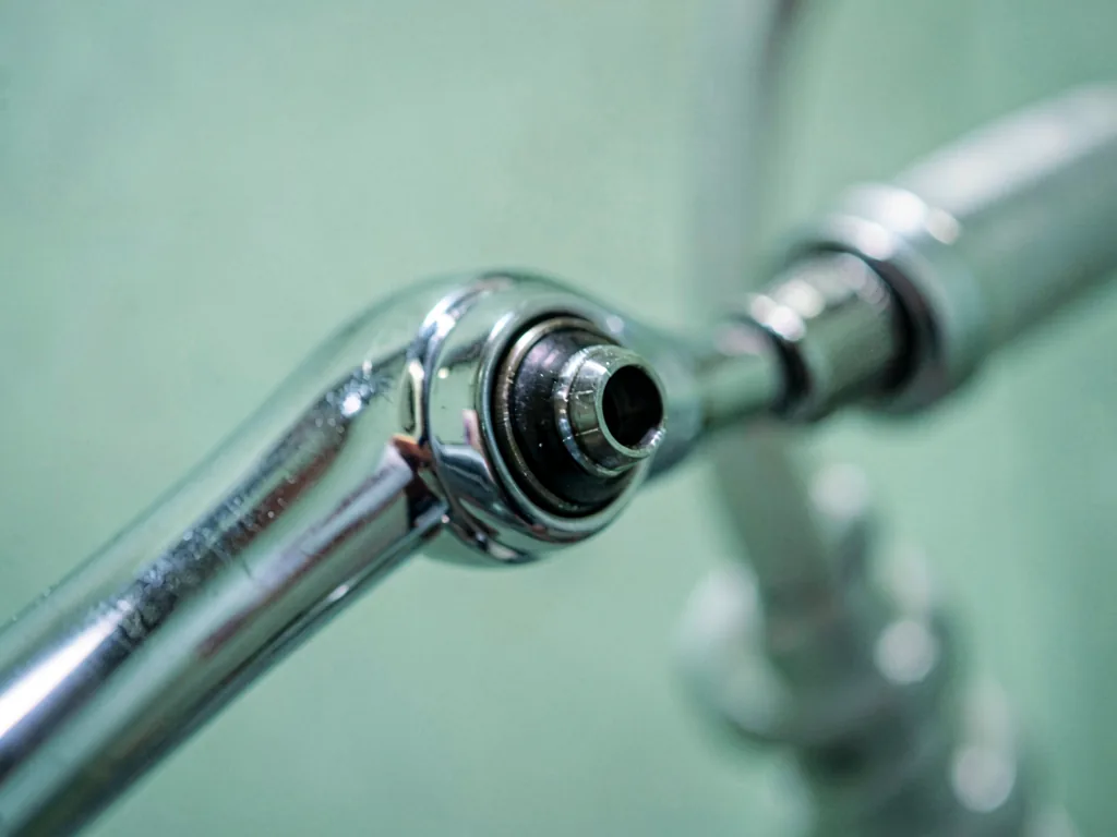The nozzle of a stand dryer on its chrome arm